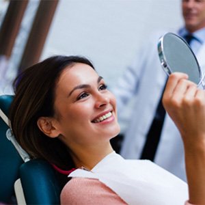 a patient smiling after paying cost of cosmetic dentistry