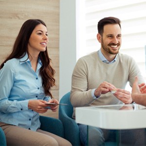 a couple discussing the cost of cosmetic dentistry with dentist