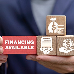 a person holding finance-related wooden blocks
