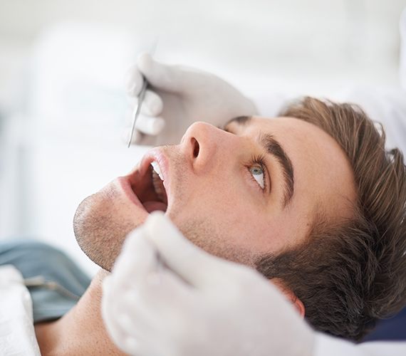 Male patient having gums cleaned
