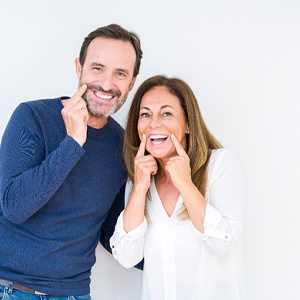 couple pointing to their smiles