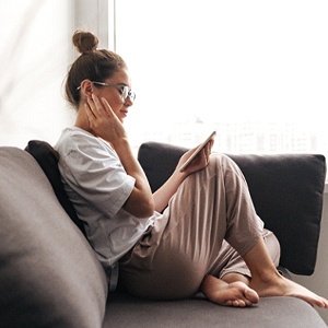 Woman with hand on face, resting after oral surgery