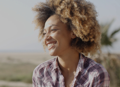 Woman with healthy smile in plaid shirt
