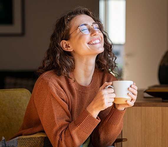a woman smiling while drinking coffee in Fort Worth