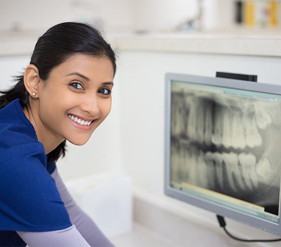 Dental team member looking at digital x-rays on computer