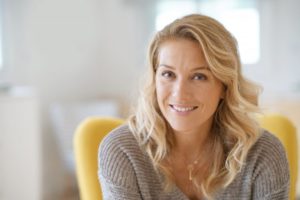 Older woman smiling after learning about dental implant cost