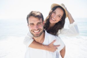 happy couple on the beach with dental implants in Fort Worth 