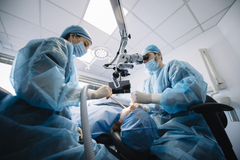 Dentists performing dental implant surgery on a patient