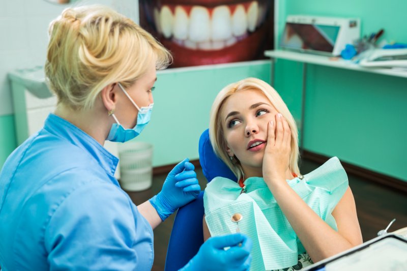 Young woman at dentist's office complaining about toothache