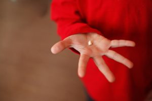 Closeup of a displaced tooth in child’s hand.