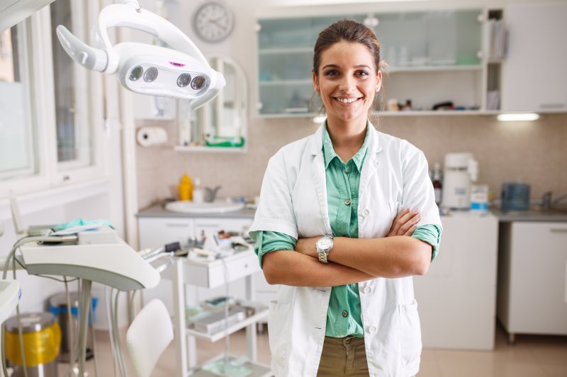 Dentist smiles in office with tools