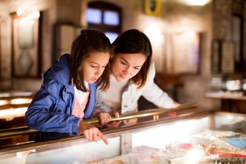 Mother and daughter looking at ancient dental crowns